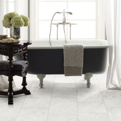 tile flooring in a elegant white bathroom with a freestanding tub by a window